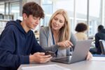 Student and teacher adviser reviewing digital exam records on secure devices