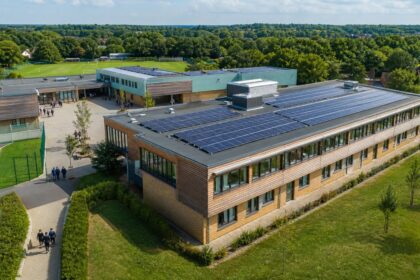 Solar panels installed across the roofs of a modern school campus in England