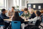 Teacher supporting a diverse group of pupils in an inclusive mainstream classroom